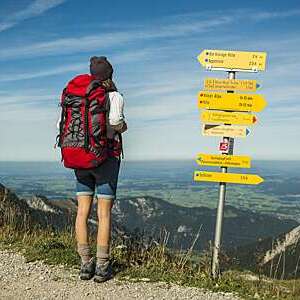 Young woman trekking in Austria, near signposts