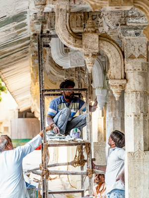 Workers repairing the facade of the City Palace in Udaipur, India