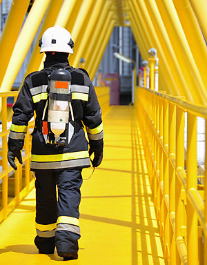 Back view of a fire fighter walking on a bridge.