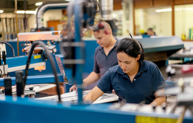 Workers printing textile in a factory.