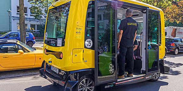 Small self-driving yellow bus on the road in Berlin.