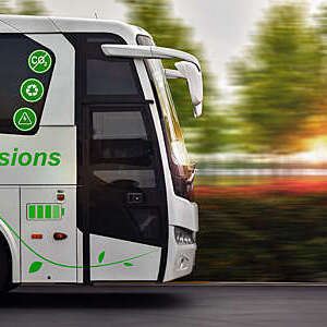 Close side view of a zero-emissions bus in motion against a blurred green background.