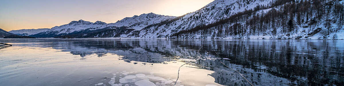 Frozen lake Sils with trapped ice bubbles and Piz Corvatsch in background, canton of Graubunden, Engadine, Switzerland